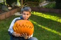 Boy holding jack-o-lantern from big pumpkin