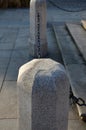 Boy holding a massive stone pillar with a chain on the square. beautifully made stone column with light granite stone profiling