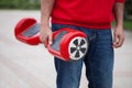 Boy holding modern red electric mini segway or hover board scooter Royalty Free Stock Photo
