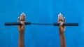 Boy holding Nunchaku on his hand isolated on Blue background. Black nunchaku training for beginner. Hot Tactical Gear Martial Arts