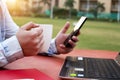 Boy is holding phone and coffee cup in hand with laptop on the table Royalty Free Stock Photo