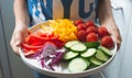 A boy carry a plate of mixed vegetable colorful salad