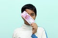 Boy holding 2000 rupee new Indian money in his hand.