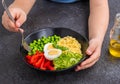 The boy is holding a salad bowl with green peas, millet, sweet pepper, fresh cucumber and boiled egg Royalty Free Stock Photo