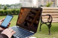 Boy is holding smartphone in hand with laptop Royalty Free Stock Photo