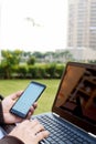 Boy is holding smartphone in hand with using laptop Royalty Free Stock Photo