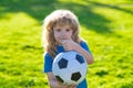 Boy holding soccer ball, close up sporty kids portrait. Soccer boy show thumbs up success sign , child play football.