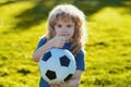 Boy holding soccer ball, close up sporty kids portrait. Soccer boy show thumbs up success sign , child play football.