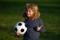 Boy holding soccer ball, close up sporty kids portrait. Young soccer player show thumbs up success sign.