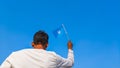 Boy holding Somalia flag against clear blue sky. Man hand waving flag of Somalia view from back, copy space