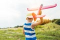 Boy holding toy airplane and preparing to launch it into the sky outdoors. Royalty Free Stock Photo