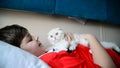 Boy holding a troublesome kitten on train