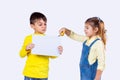 The boy holding a white clean paper in his hand and girl tries to cut the paper carefully with the help of scissors. Royalty Free Stock Photo
