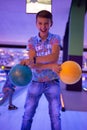 A boy holds bowling balls posing for the camera Royalty Free Stock Photo