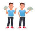 The boy holds dollar bills in his hand and shows the OK sign with his other hand. A beautiful child in a blue T-shirt with money
