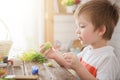 Boy holds an egg and painting with brush. Preparing for celebration of Easter. Little boy painting and decorating Easter