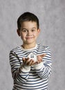 The boy holds in his hands the little white house. The concept of real estate, purchase, adoption.