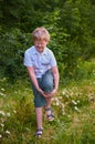 Boy holds his leg and winces at the pain in the Park Royalty Free Stock Photo