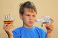 Boy holds model of sailing ship and ship in bottle Royalty Free Stock Photo