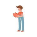 The boy holds a pink pig piggy bank in his hands and looks at it. The image is about financial literacy, children's