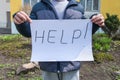 Boy holds a sheet of paper with the words Help Royalty Free Stock Photo