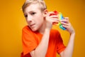Boy holds a silicone antistress toy in front of him tries to pop balls and listens