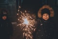 Boy Holds A Sparkler In His Hands While Celebrating A New Year On The Street At Night.