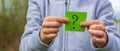 the boy holds stickers with a question mark on the background of the park. selective focus Royalty Free Stock Photo