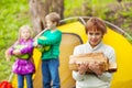 Boy holds the wood for camping bonfire in forest