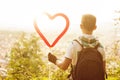 Boy with hoodie holding a heart ballon