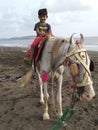 Boy on horse with traditional style near sea Royalty Free Stock Photo