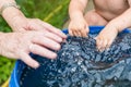 A boy and hos grandmother washe hands in the water barrel Royalty Free Stock Photo