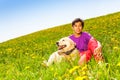 Boy hugging dog sitting on green grass in summer Royalty Free Stock Photo