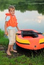 Boy and inflatable boat ashore Royalty Free Stock Photo