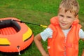 Boy and inflatable boat on lawn Royalty Free Stock Photo