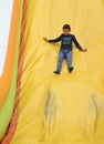 Boy on inflatable bouncy castle slide Royalty Free Stock Photo