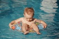 Boy on an inflatable wheel in the pool. baby swims. Baby and rest