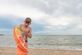 The boy inflates a swimming ring on the seashore