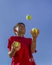 Boy juggles tennis balls. Royalty Free Stock Photo