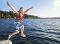 Boy jumping into a beautiful mountain lake. Having fun on a summer vacation Royalty Free Stock Photo