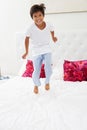 Boy Jumping On Bed Wearing Pajamas Royalty Free Stock Photo
