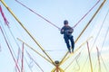 The boy is jumping on a bungee trampoline. A child with insurance and stretchable rubber bands hangs against the sky. The concept Royalty Free Stock Photo