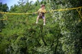 The boy is jumping on a bungee trampoline. A child with insurance and stretchable rubber bands hangs against the sky. The concept Royalty Free Stock Photo