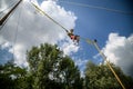 The boy is jumping on a bungee trampoline. A child with insurance and stretchable rubber bands hangs against the sky. The concept Royalty Free Stock Photo