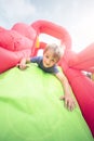 Child on inflatable bouncy castle slide