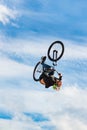 Boy jumping a high stun over head on a mountain bike. Young rider at the wheel of his bmx makes a back flip trick. Extreme sport. Royalty Free Stock Photo