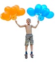 Boy jumping holding a bunch of balloons, orange and blue Royalty Free Stock Photo