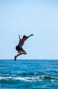 Boy jumping off cliff into the sea. Royalty Free Stock Photo