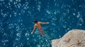 Boy jumping off rock into Aegean Sea