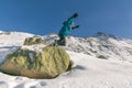 Boy jumping of a rock into snow